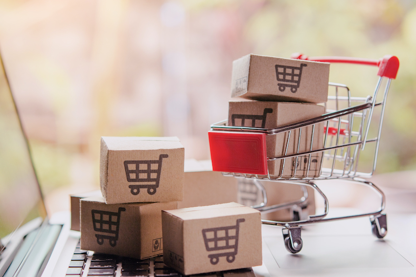 Shopping online concept - Parcel or Paper cartons with a shopping cart logo in a trolley on a laptop keyboard. Shopping service on The online web. offers home delivery.